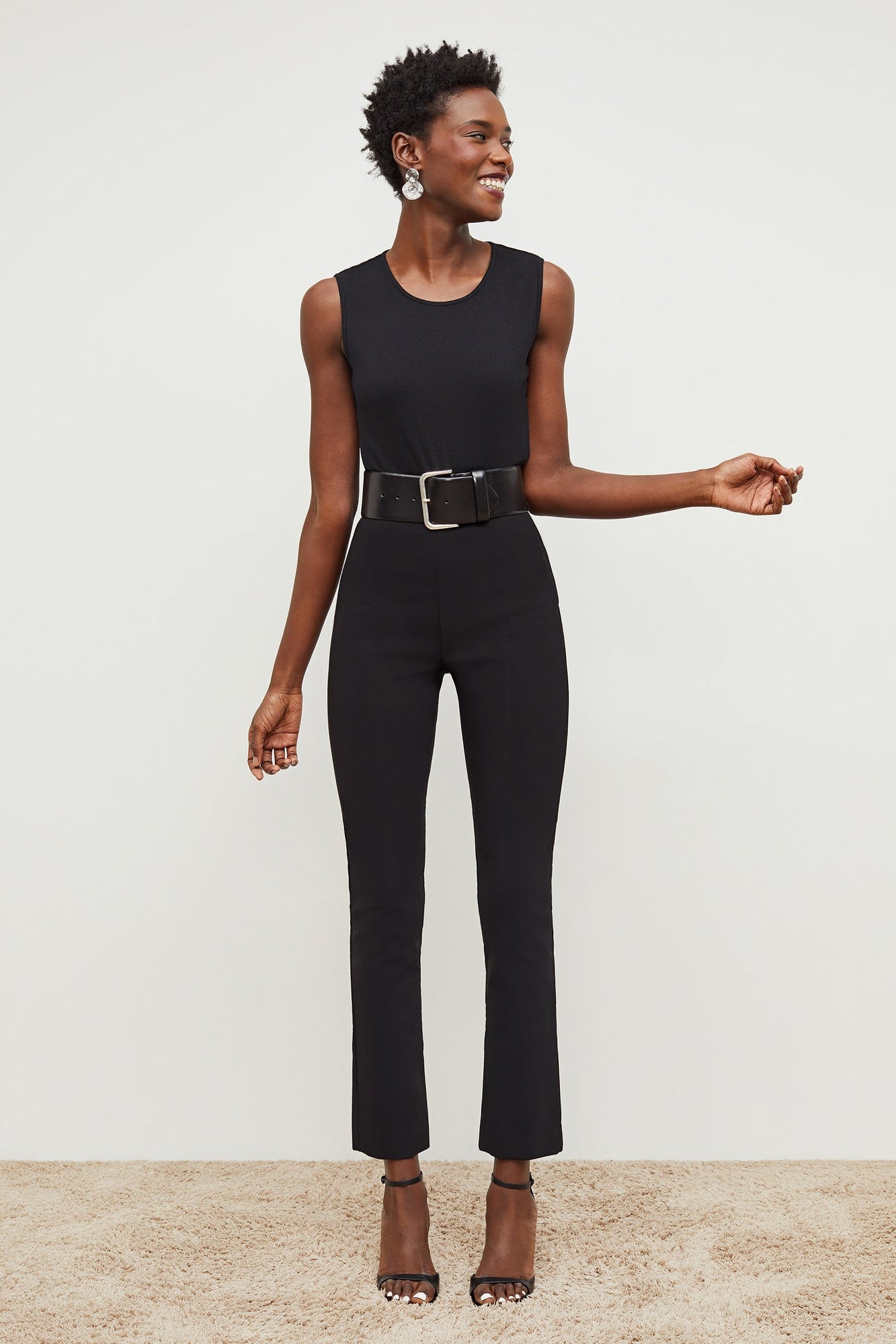 Front image of a woman standing wearing the Foster Pant—Everstretch in Black | Exclude
