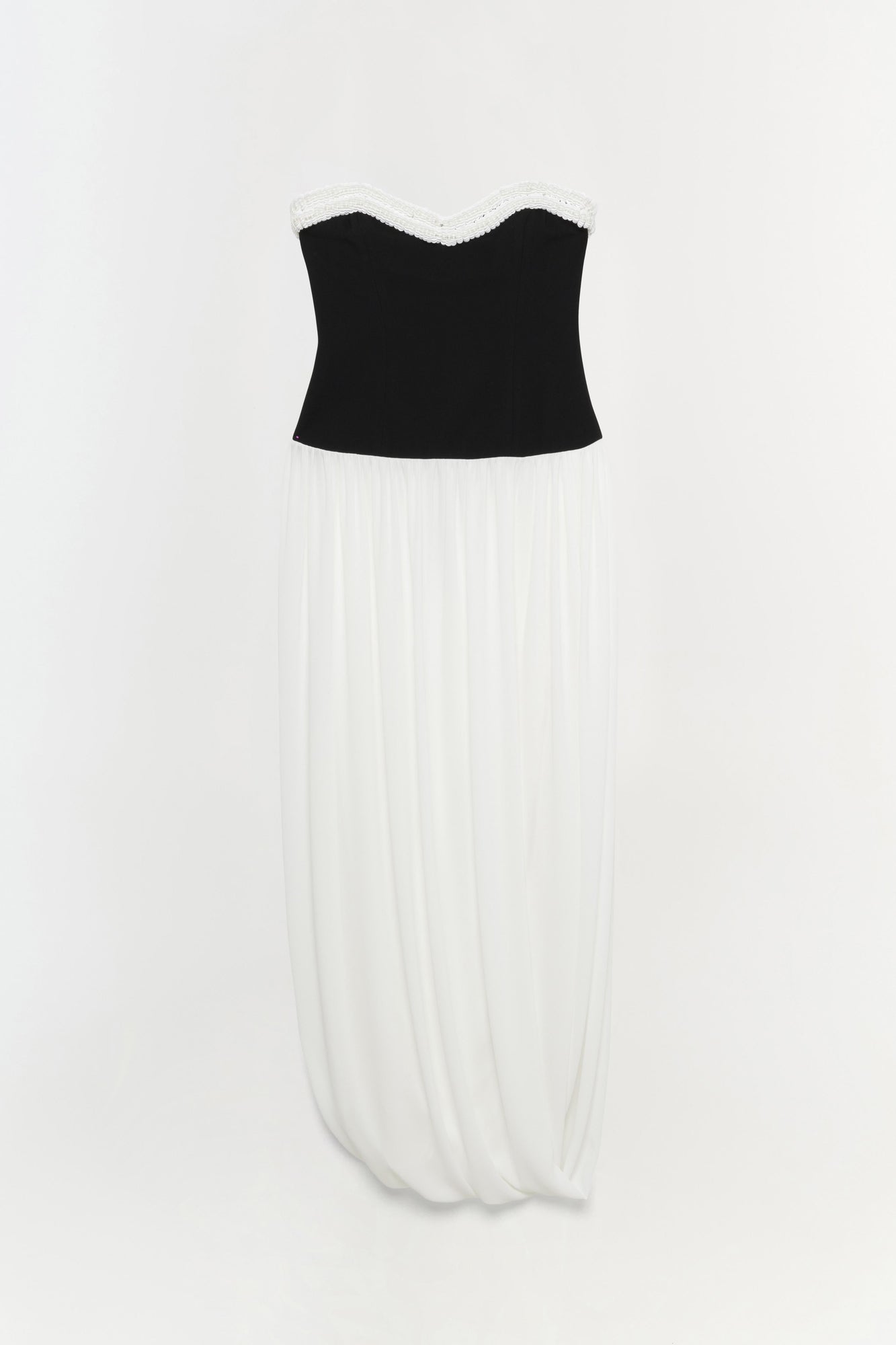 Strapless dress with black bustier top, white lace neckline trim, and ivory pleated skirt.