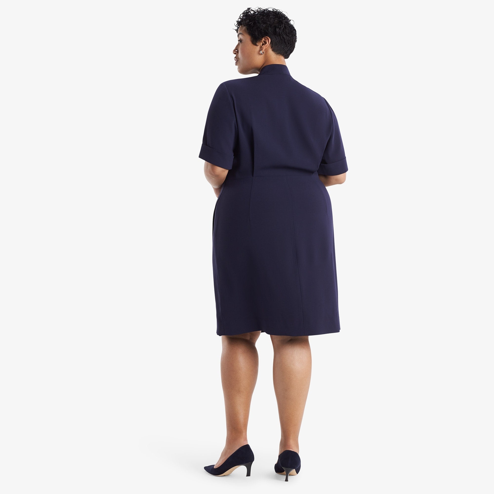 Back image of a woman standing wearing theTory Dress in dark iris