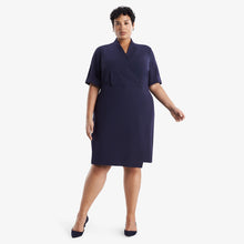 Front image of a woman standing wearing theTory Dress in dark iris