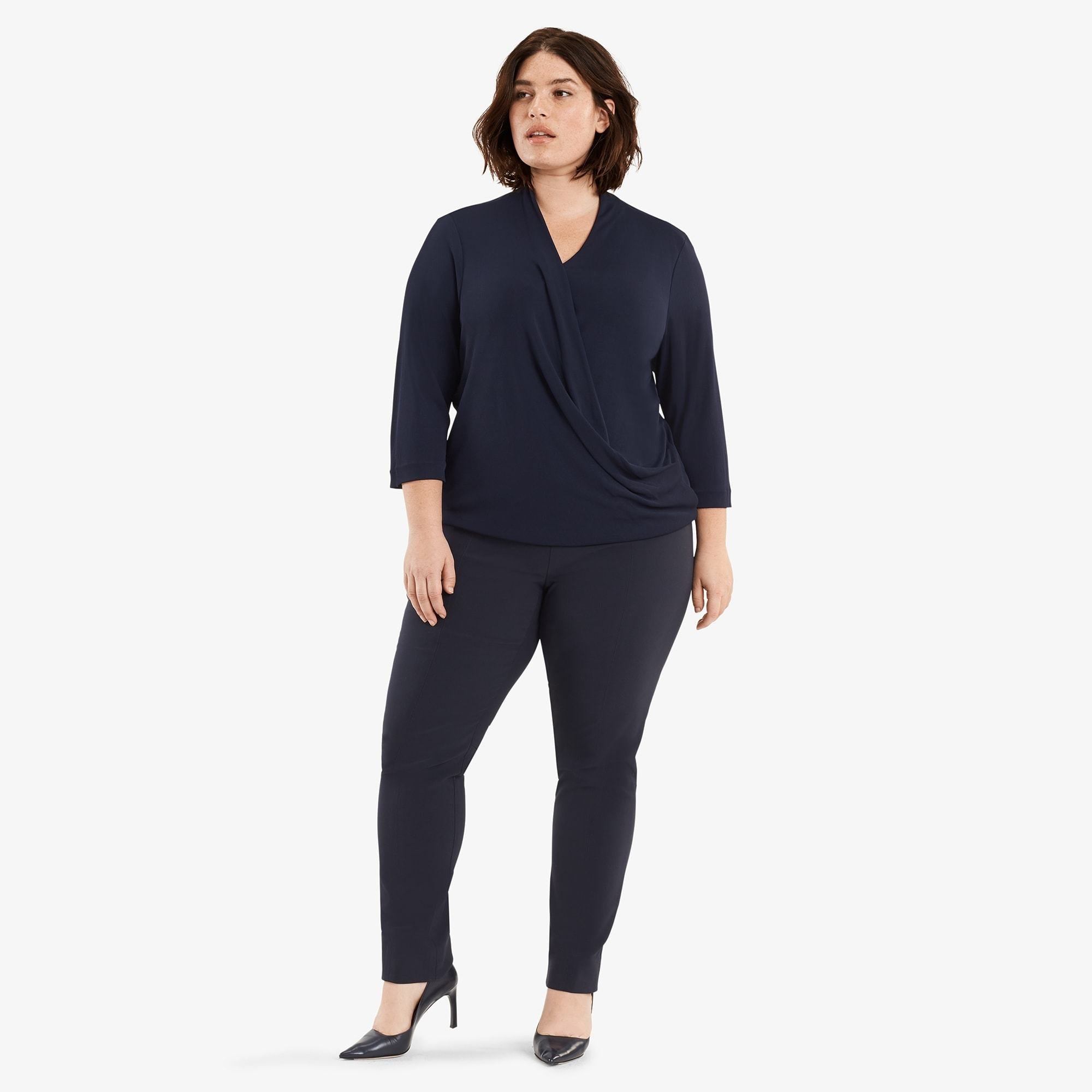 Hero image of a plus size woman posing wearing the Foster pant in dark navy and the Deneuve shirt in galaxy blue. | Exclude