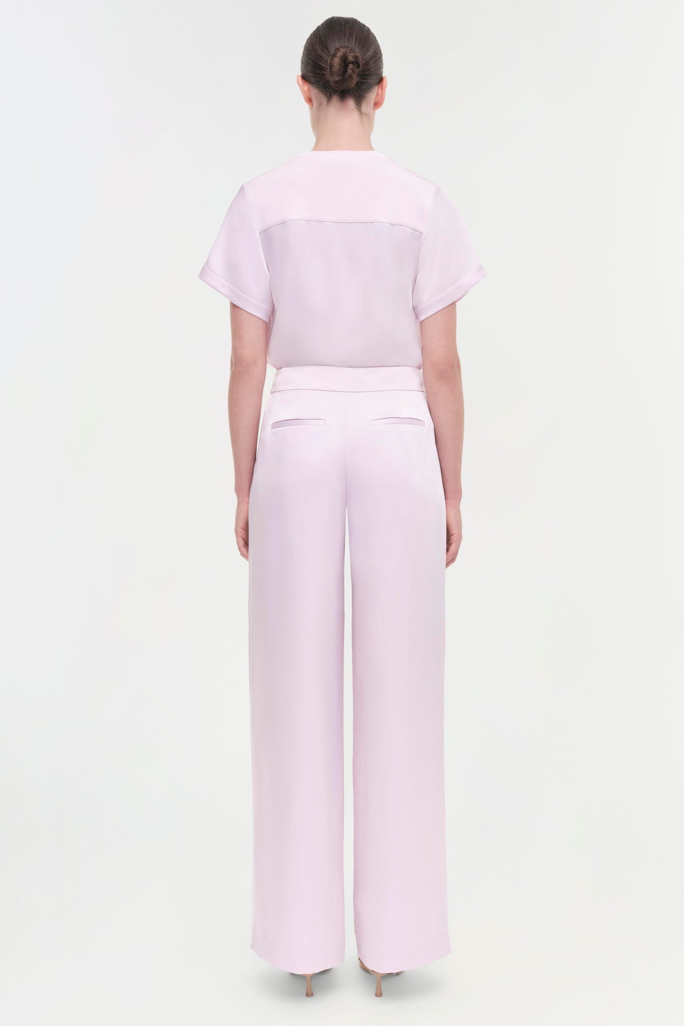 Light pink wide-leg pant with high waist and back pocket detail, shown on model from behind.