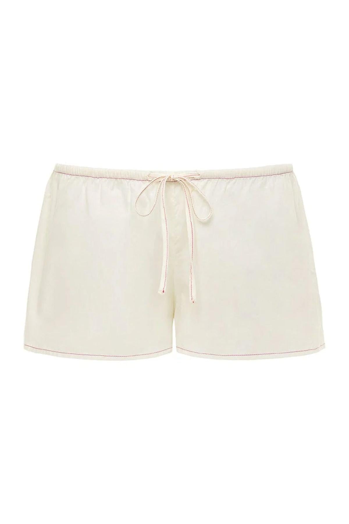 Cream low-rise drawstring shorts with raspberry pink trim stitching and tie waist.