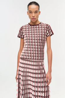 Brown and pink knit midi skirt with scalloped edges worn with matching short-sleeve geometric patterned top.