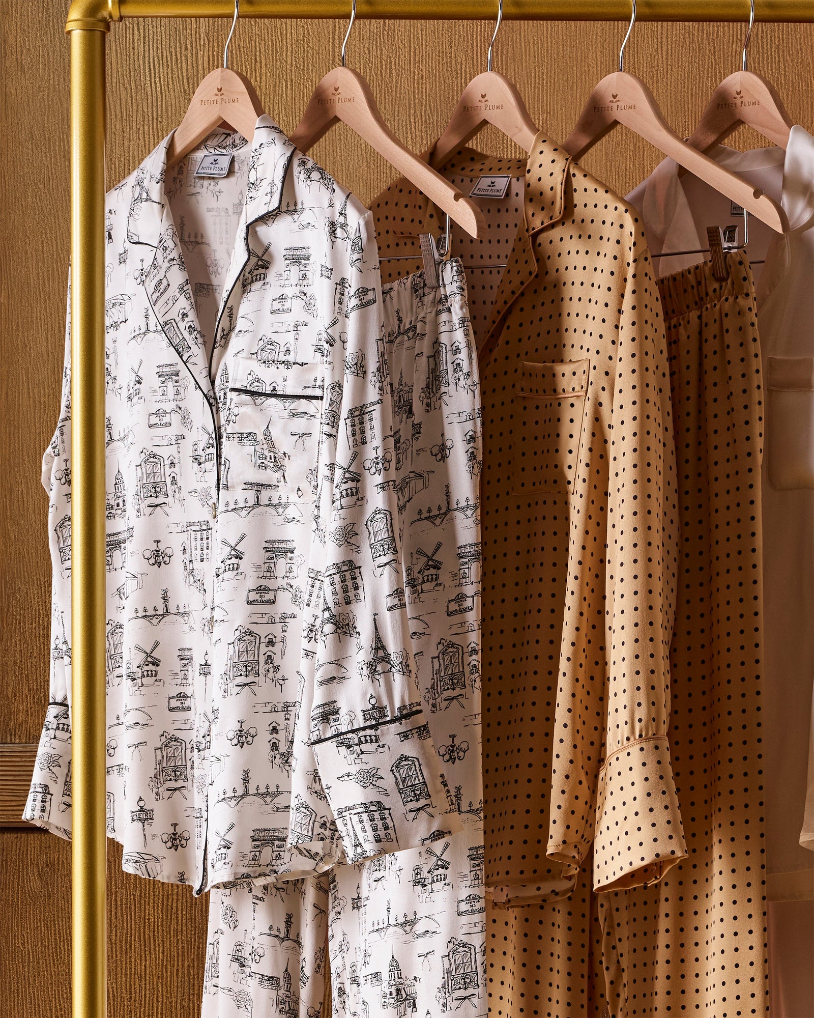 The Women's Silk Pajama Set features a gold fabric with black polka dots, including a long-sleeve button-up top with chest pocket and matching drawstring pants.