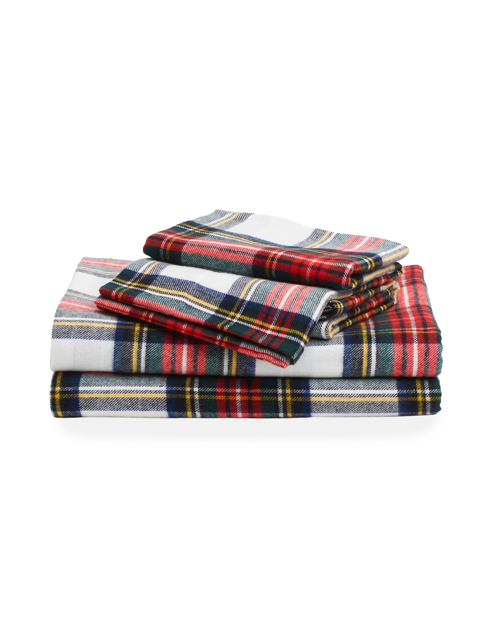 Close-up of a bed adorned with Petite Plumes Flannel Sheets in Balmoral Tartan, showcasing plaid sheets and pillowcases accented with red, green, blue, and yellow stripes on white. The cozy cotton brushed flannel creates a warm and inviting atmosphere.