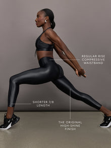 Model wears a mid rise waisted pair of liquidy shine black leggings that hit at model's mid to low calf.