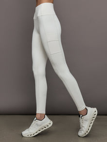 Model wears a highly compressive white high waisted legging with side pocket on outer thigh. 