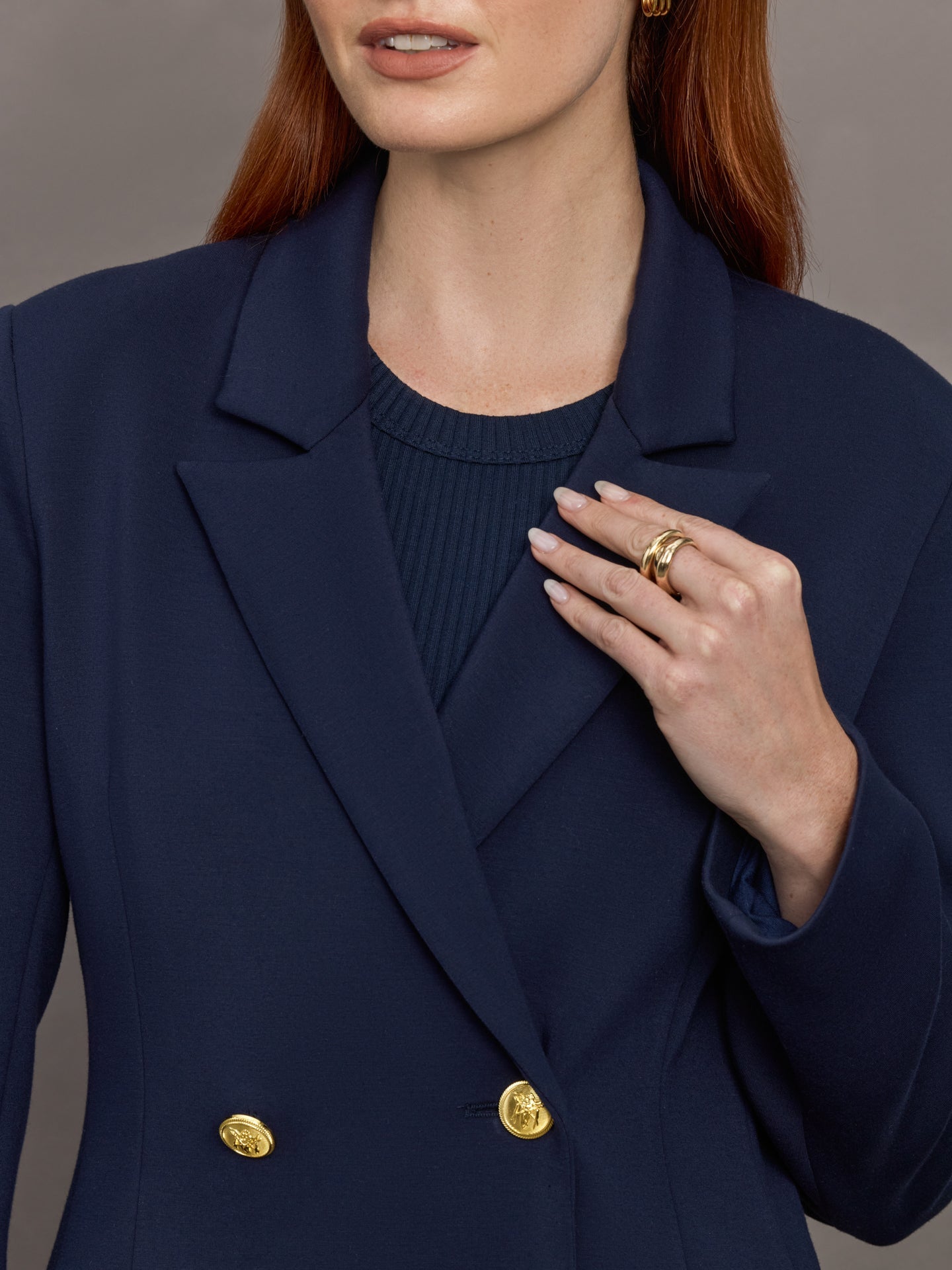 Model wears the Navy double-breasted blazer in Scuba, with a tailored fit, and a smooth, contoured finish.