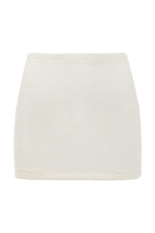 Cream-colored terry cloth micro skirt with ribbed texture and elastic waistband.