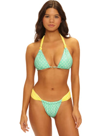 Woman wearing a green and yellow bikini with a white background