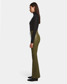 Woman in profile against a white background, wearing a fitted black turtleneck, CARISSA - 8524545 Loden Green leather pants by Rudsak with a high-waisted flared silhouette, and black ankle boots.
