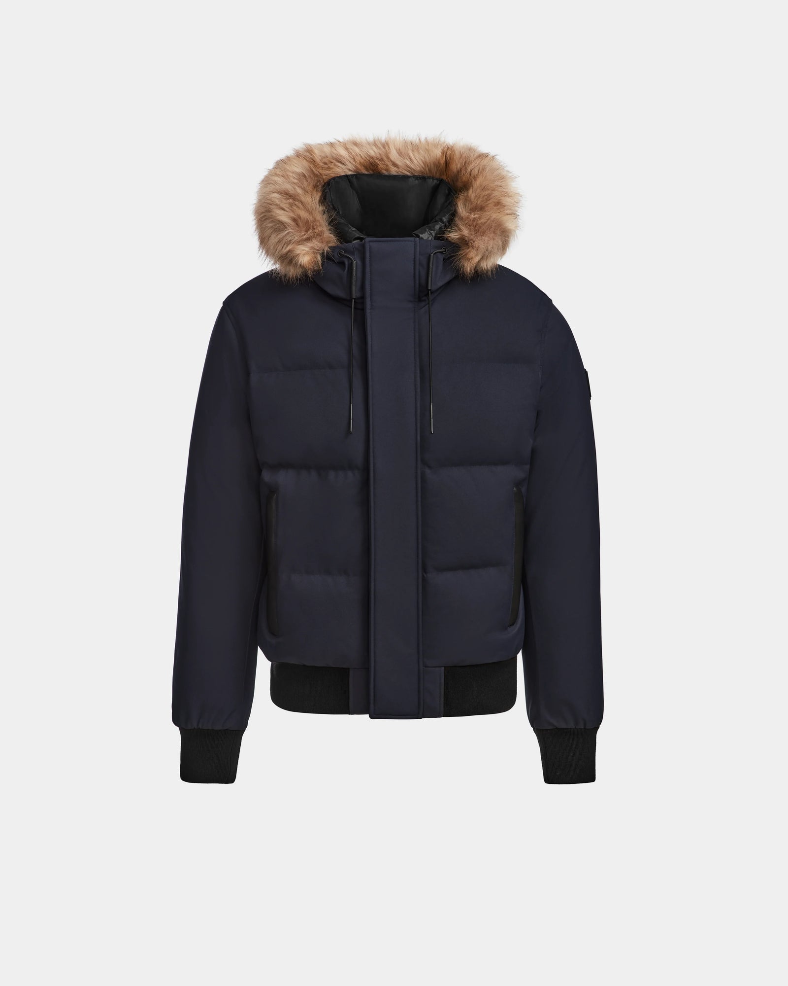 The Rudsak DALLAS - M122501 Navy men's bomber is a quilted down jacket with a fur-lined hood, front zipper, snap buttons, and black ribbed cuffs and hem, made from RDS-certified down, shown on a plain light background.