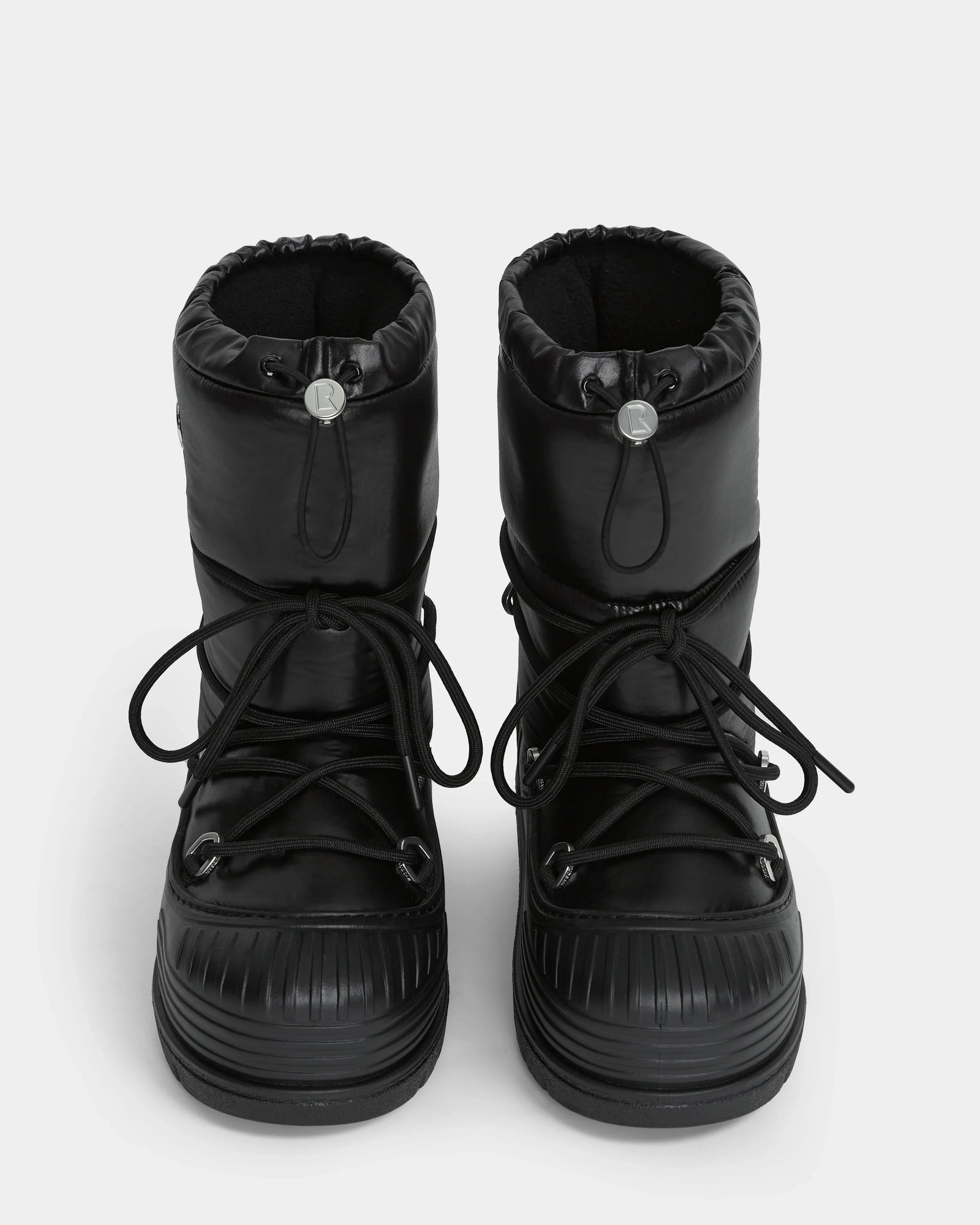 The Rudsak KIKA - L224506 Black women's winter boots feature a puffy design, chunky rubber soles, front laces, and drawstring closures, displayed from the front on a white background.