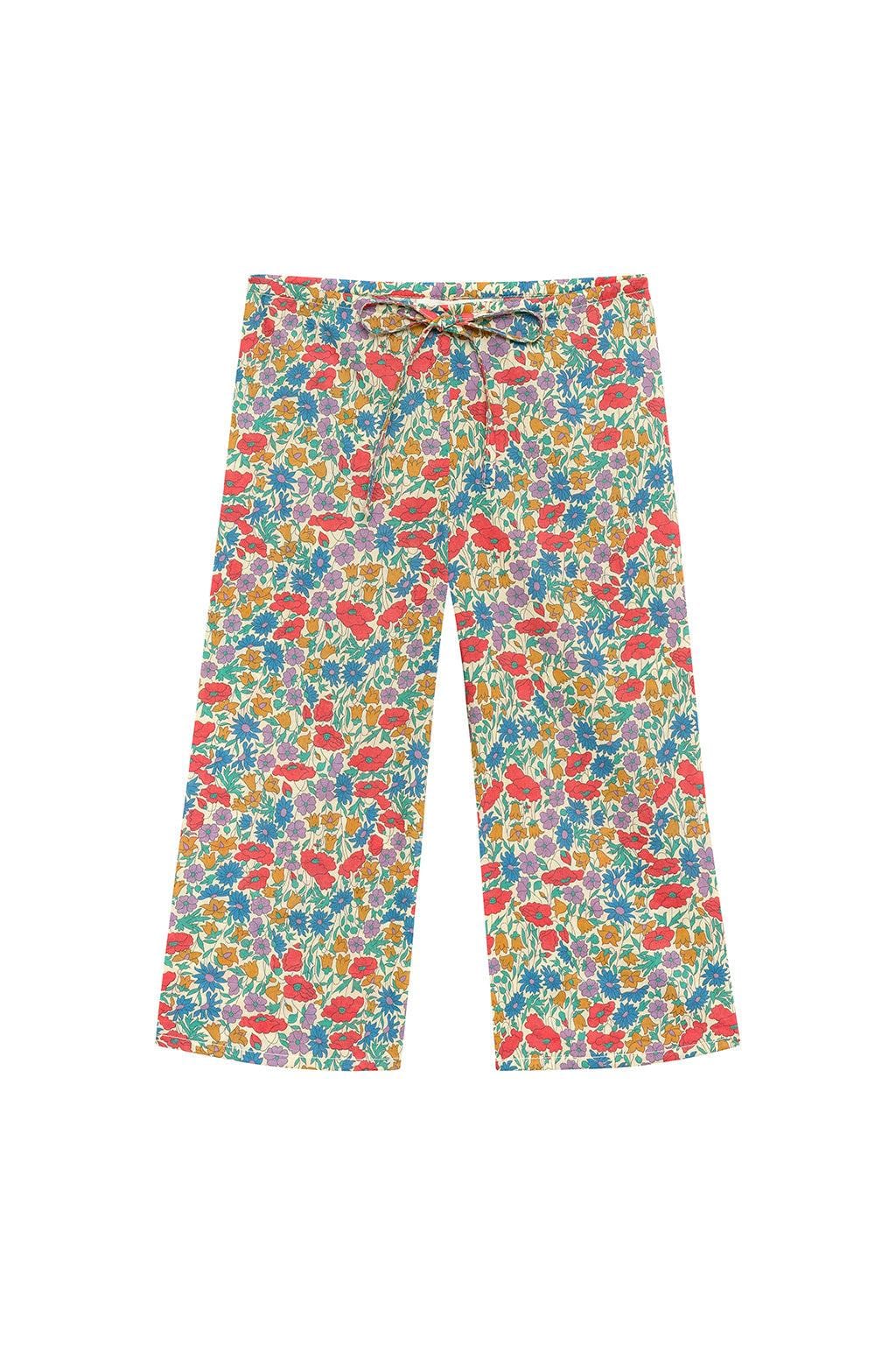 Multicolored floral print drawstring pants with red, blue, yellow, and purple flowers on cream background.