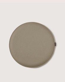 A round, flat, light brown cushion or pad by Graf Lantz with a smooth surface, resembling Zabuton seat cushions, placed on a plain light background.