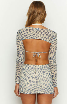 Rear view of a cream sheer star print bolero with long sleeves and an open back, revealing the tie-back closure of the matching top
