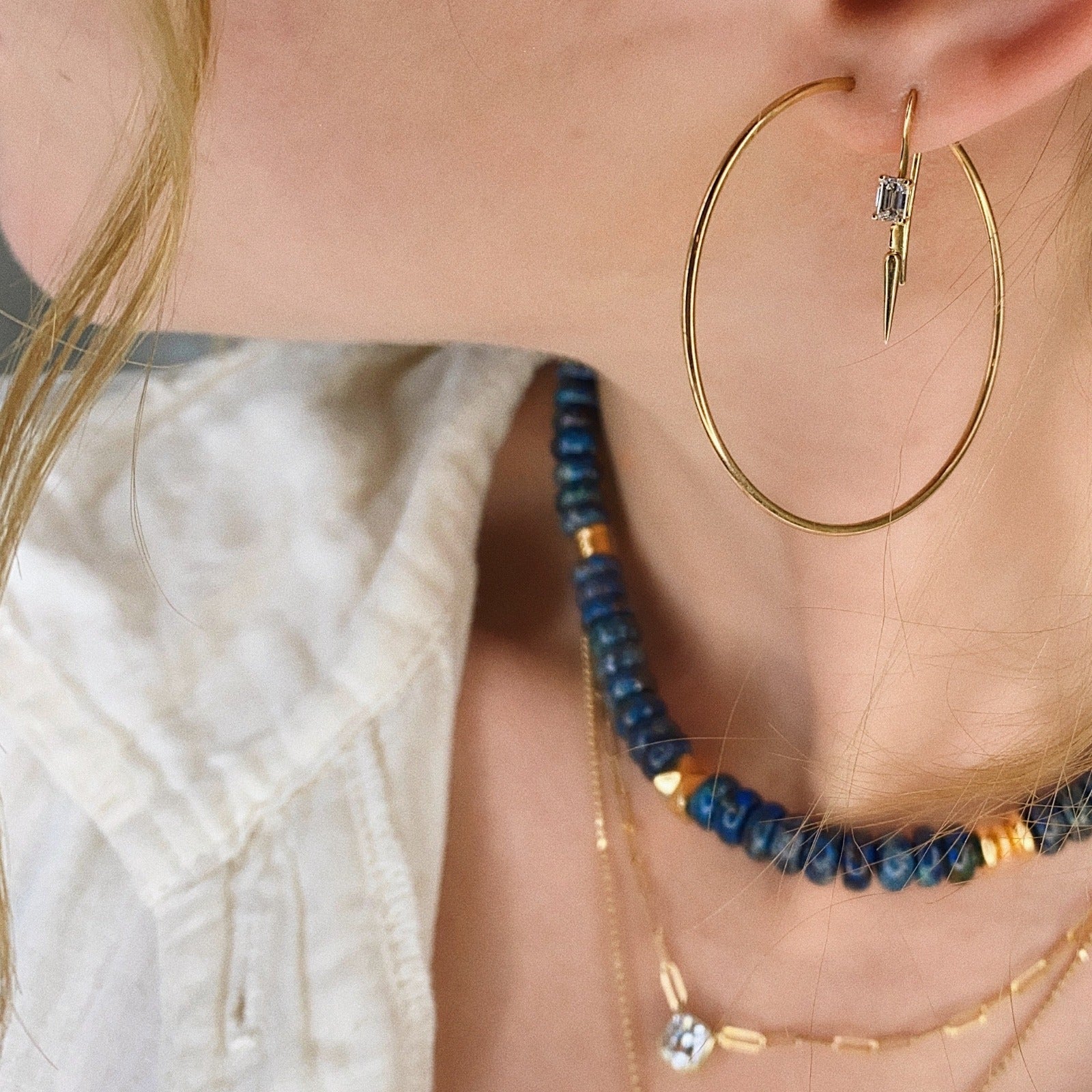 14k gold Endless Hoop Earrings styled on a ear