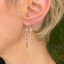 14k gold Single Diamond Drop Earrings in emerald cut on an ear