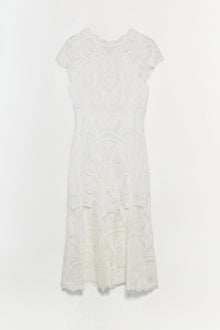 White lace dress with short sleeves, ornamental patterns throughout, and scalloped hemline.