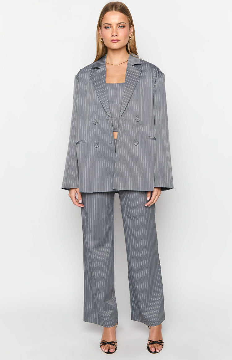 Front view of a grey pinstriped oversized blazer worn open over a matching crop top and wide-leg pants