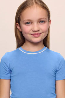 Model is wearing the Kids TENCEL Modal Unisex Short PJ Set in cornflower blue/white