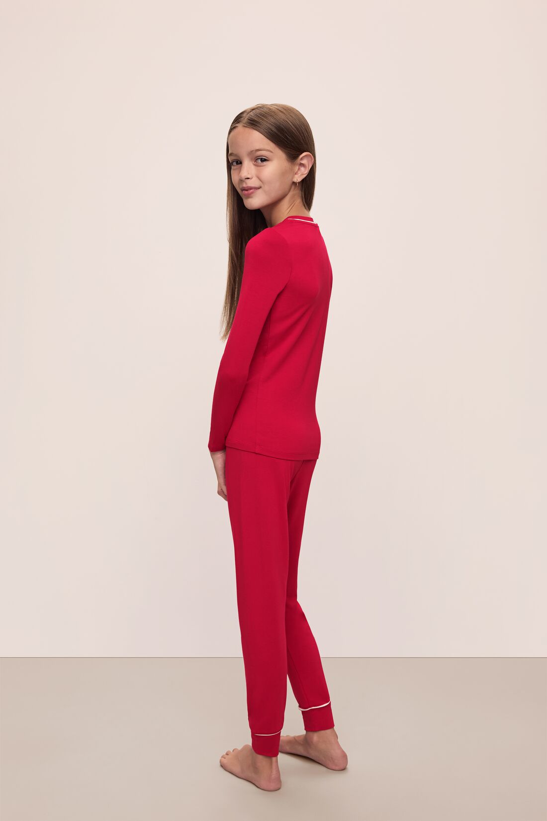 Model wears Kids TENCEL Modal Unisex Long PJ Set in Haute Red/Ivory.