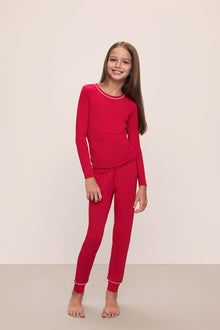 Model wears Kids TENCEL Modal Unisex Long PJ Set in Haute Red/Ivory.