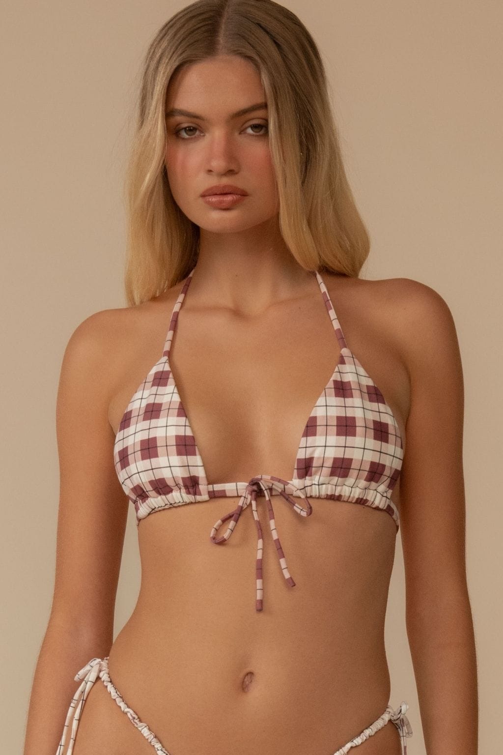 Maroon and cream plaid halter bikini top with tie closure, shown on model against neutral background.