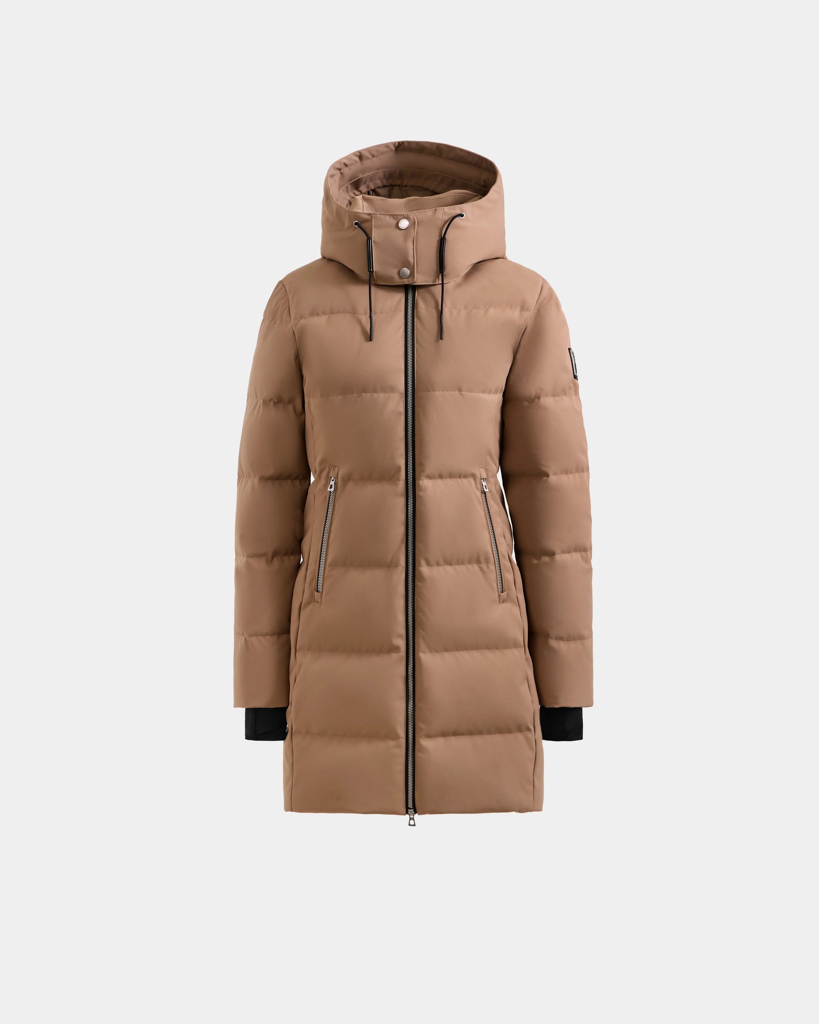 The MIRIAM - L123544 Sand by Rudsak is a light brown, knee-length women’s down puffer coat with a hood, front zipper, two zippered side pockets, horizontal quilting, and black drawstrings. Weather-resistant for winter wear.