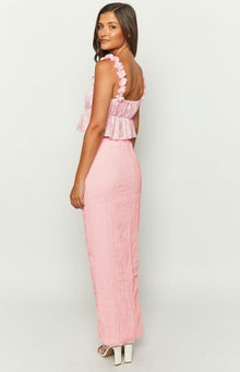 Close-up of the pink top's ruffled shoulder straps, shirred bodice, and textured peplum hem