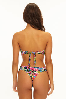Woman wearing a colorful floral bikini on a white background