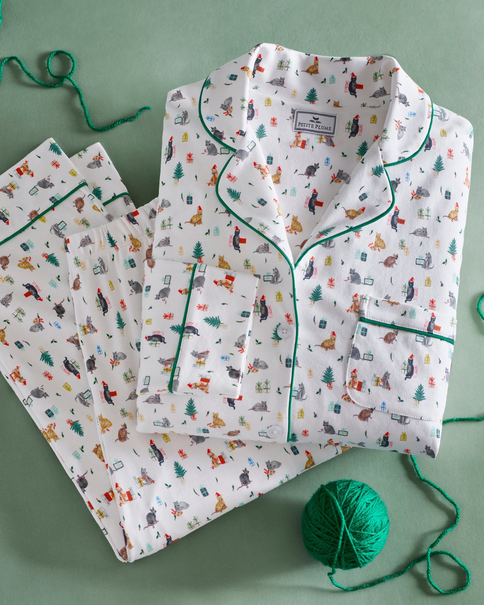 Men's Pima Pajama Set in Merry Meow: white set with green piping, featuring an all-over print of playful colorful cats. Includes a long-sleeve button-up shirt with chest pocket and matching pants.