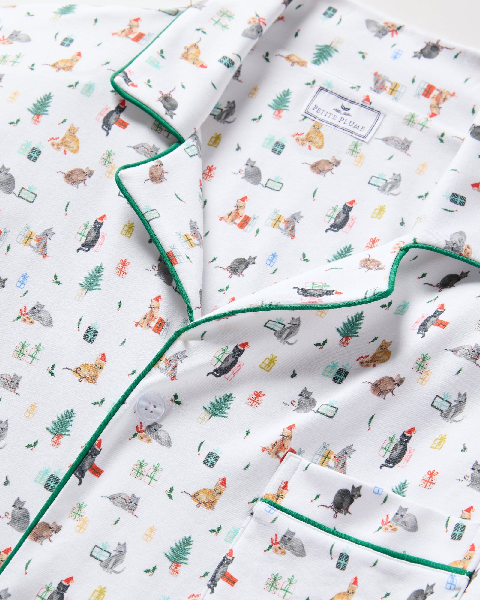Men's Pima Pajama Set in Merry Meow: white set with green piping, featuring an all-over print of playful colorful cats. Includes a long-sleeve button-up shirt with chest pocket and matching pants.