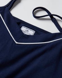 The Women's Pima Sylvie Pajama Set in Navy includes a sleeveless V-neck camisole with thin straps and matching long pants, both featuring white trim. The set is displayed flat on a white background.