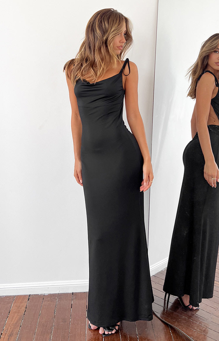 Black maxi dress with cowl neck and tie spaghetti straps, mirror reflection shows the low back and side cutouts