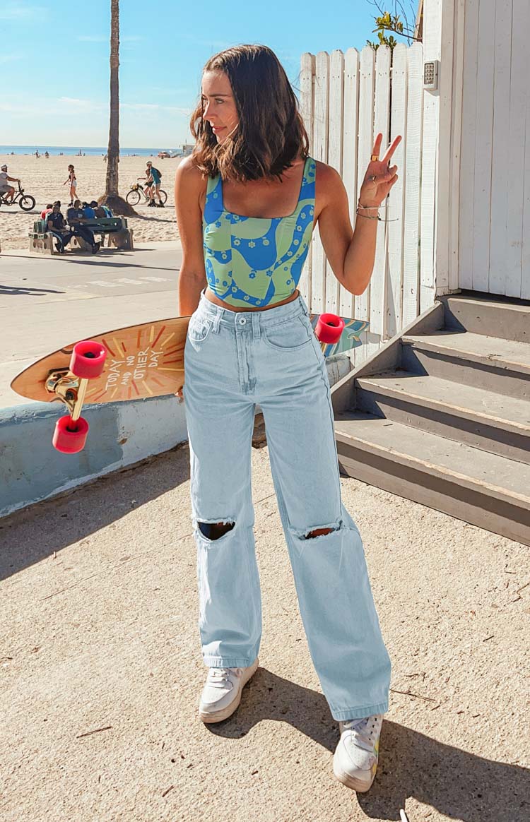 Light blue high-waisted wide leg jeans with distressed denim and large rips at the knees