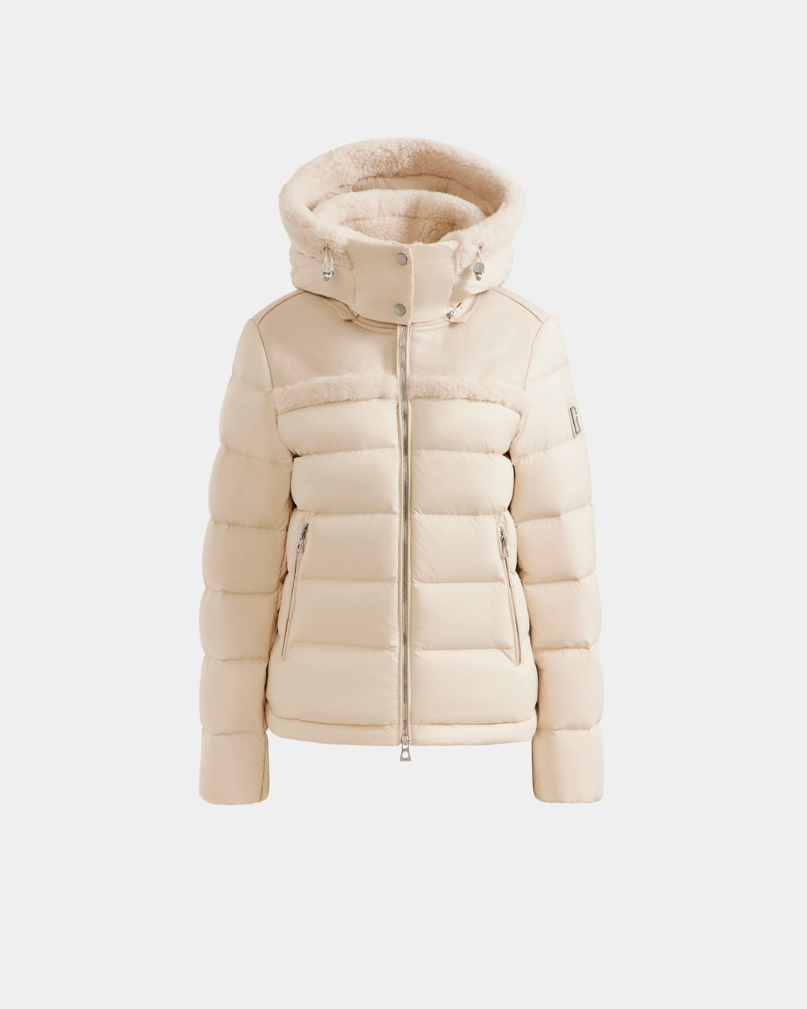 The Rudsak SANDRA - 8125612 Vanilla is a cream-colored shearling puffer jacket featuring a thick, fur-lined hood, front zipper, and side zip pockets, shown against a plain white background.