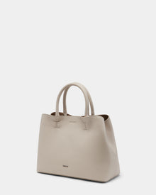 The Rudsak CATIRA S - 8325006 Vanilla is a large, light beige womens pebble leather tote with two rounded handles, subtle textured finish, minimal branding near the bottom, and is shown against a plain white background.