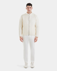 A man stands facing forward, wearing the REYMOND - M125013 Iceland off-white quilted men’s down jacket by Rudsak, paired with matching white pants and white sneakers against a plain white background.