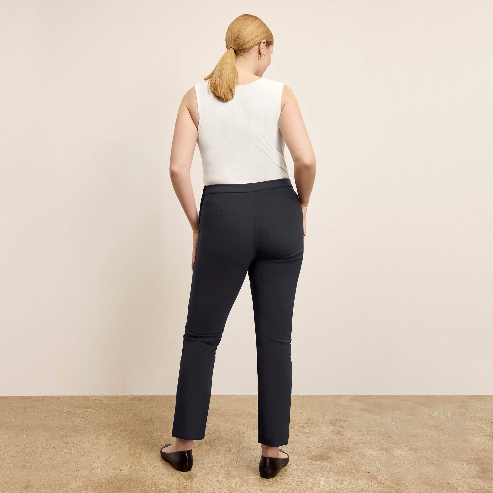 back image of a woman standing wearing the Foster Pant—Everstretch in Black | Exclude