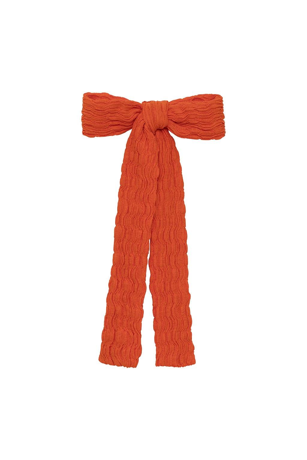 Tangerine hair ribbon with textured fabric and bow knot detail, featuring long trailing ends.