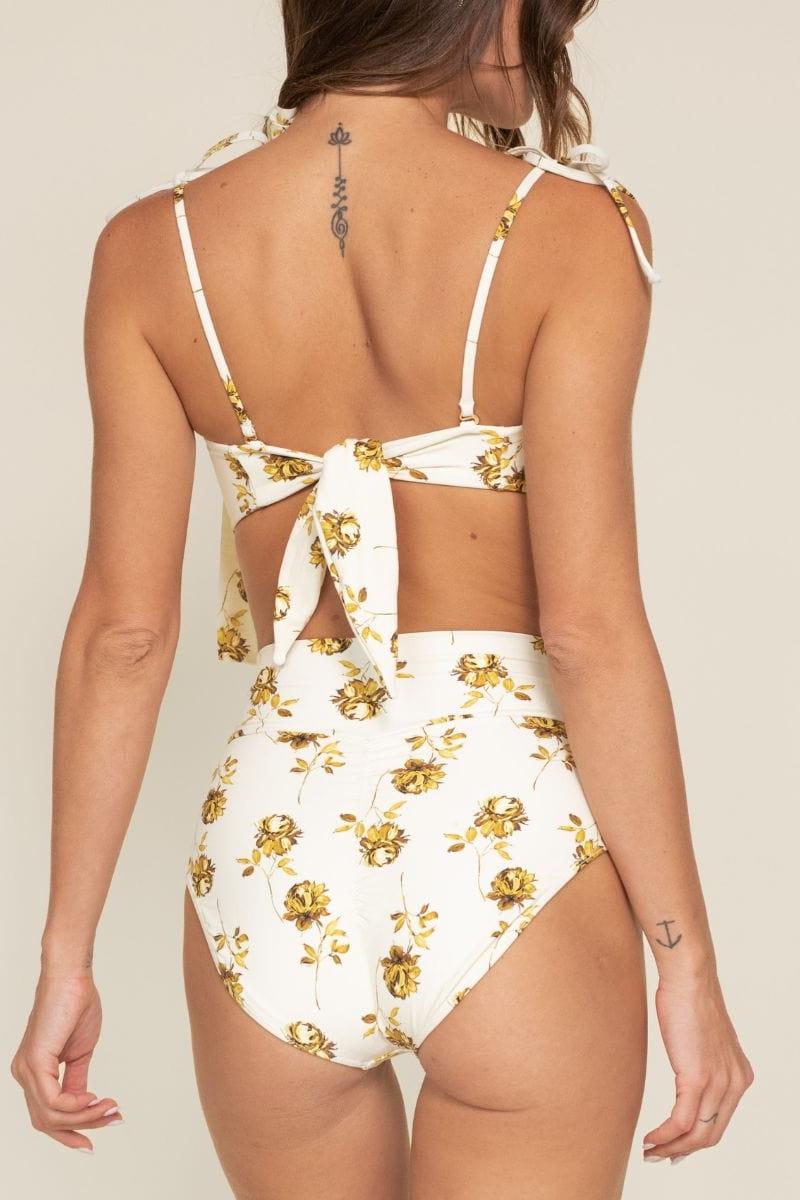White high-rise bikini bottom with gold filigree floral print and moderate coverage.