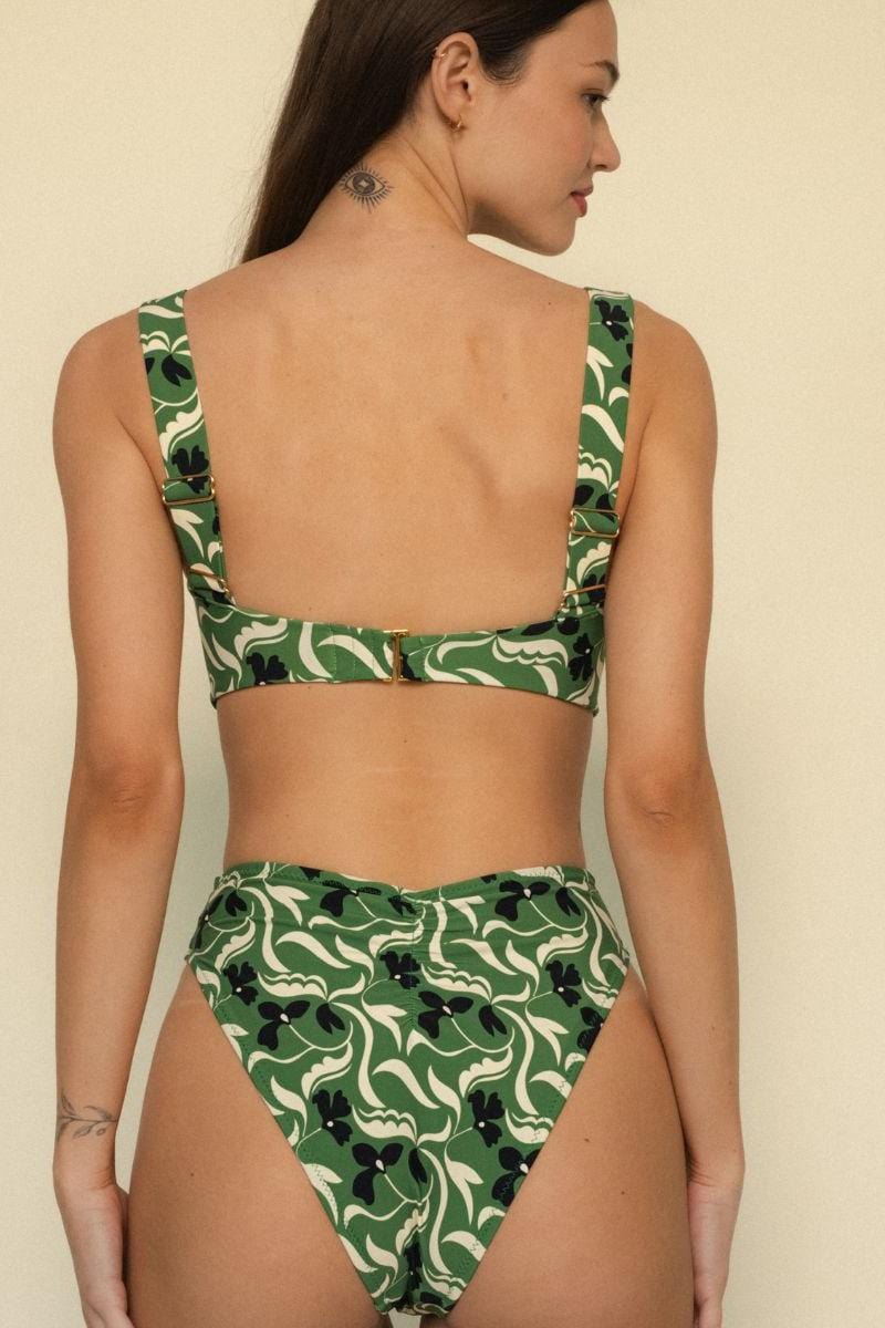 Green and cream floral bikini top with black accents, shown from back view on model.