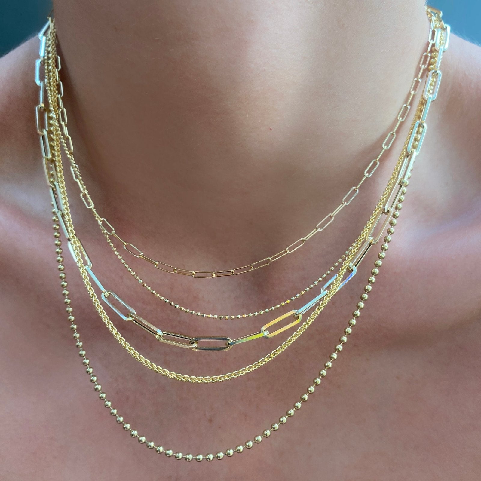 14k Yellow Gold Chains styled together on a neck