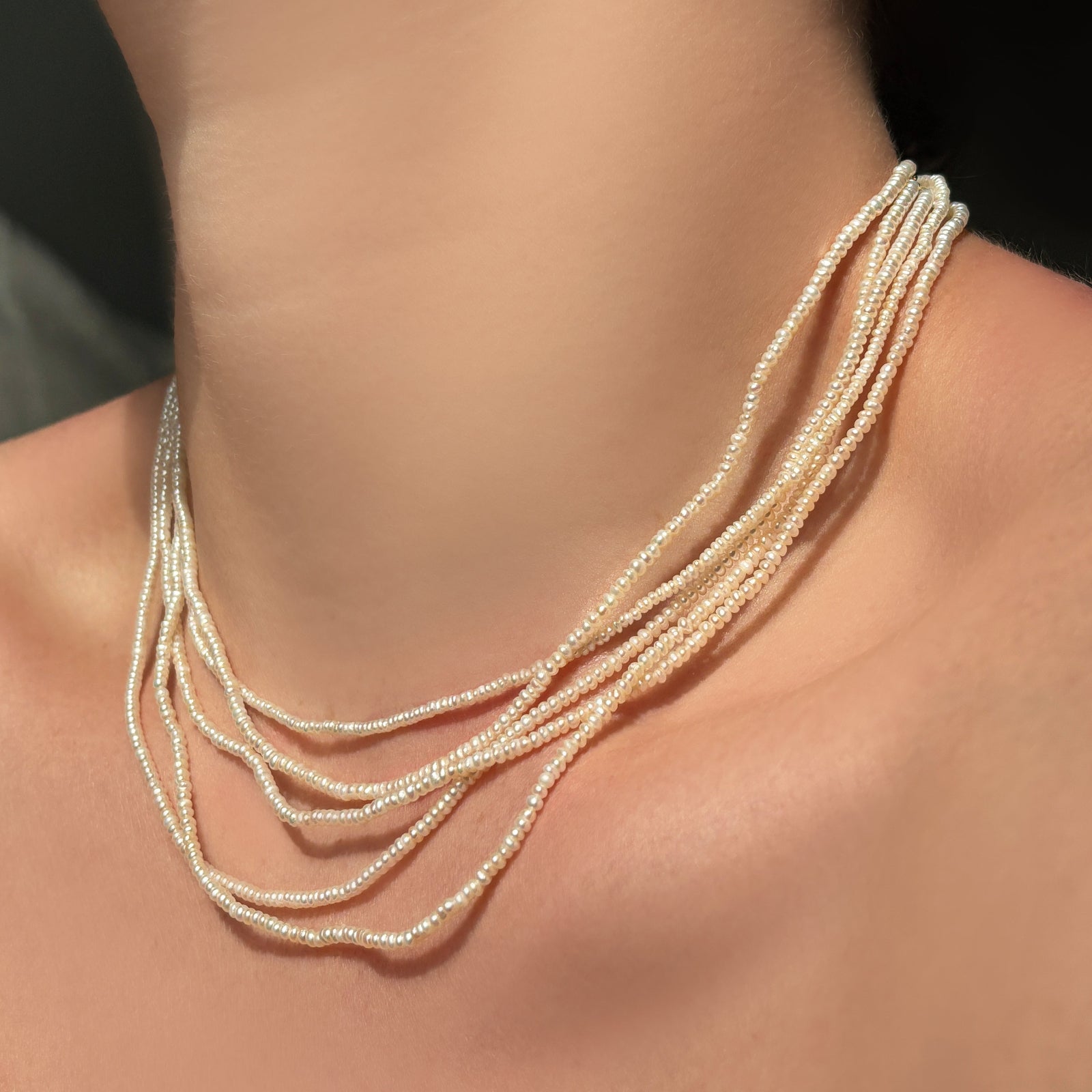 Slim 2mm pearl necklace layered in a stack of five.