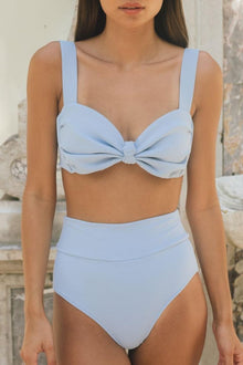 Light blue ribbed high-rise bikini bottom with added coverage and matching bow-front bikini top.