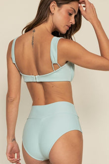 Powder blue high-rise bikini bottom with full coverage fit, shown from back view on model.