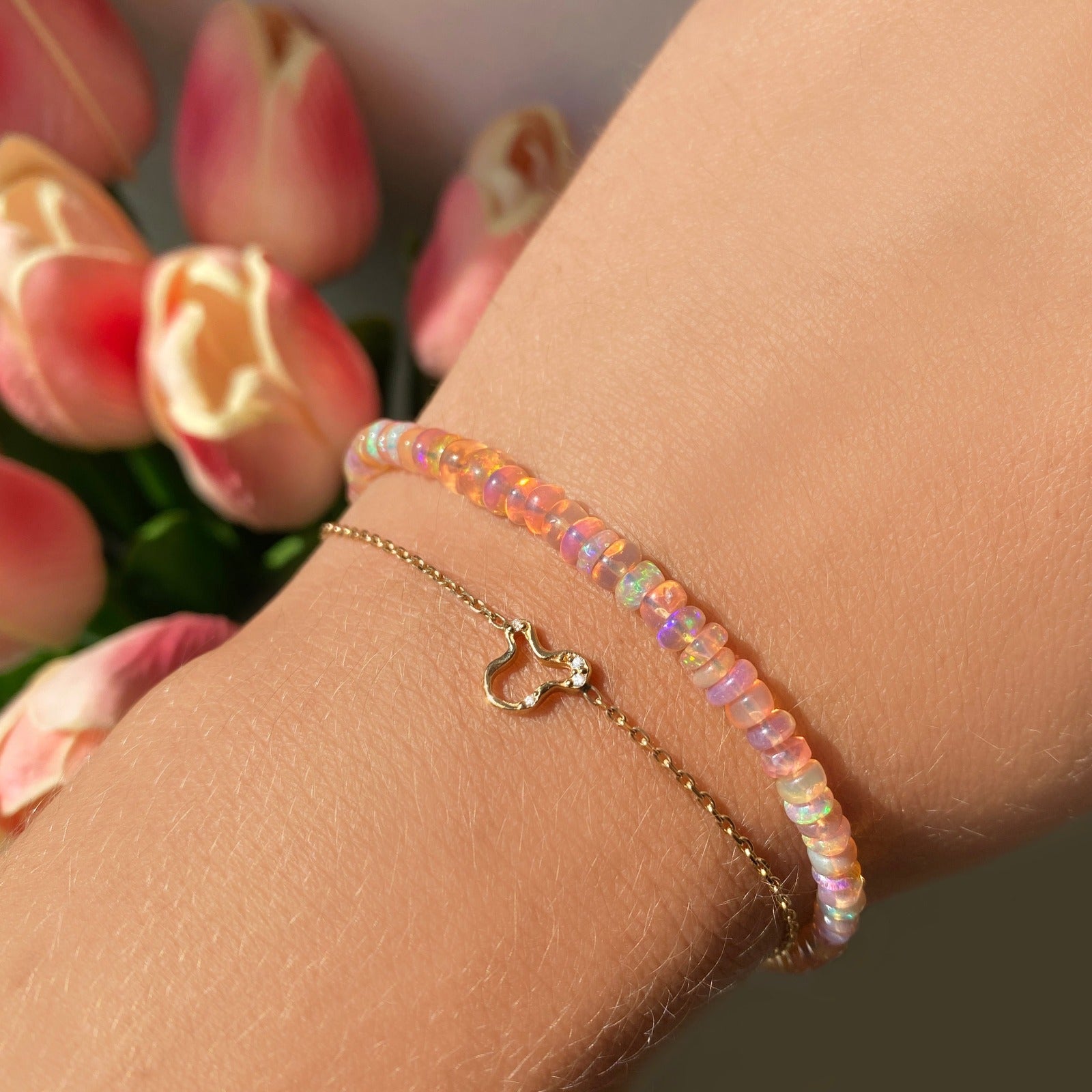 14k gold Demi Pave Ripple Chain Bracelet styled on a wrist styled with a blush smooth opal bracelet
