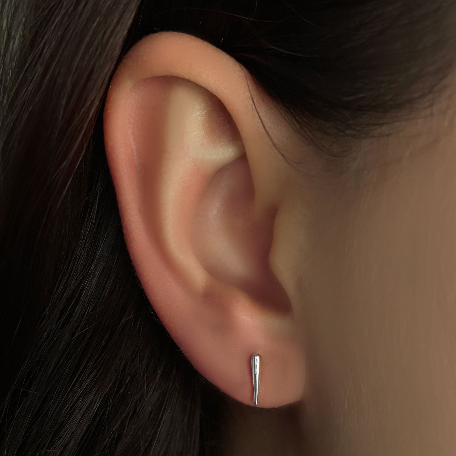 Small quill spike stud in white gold on the ear.